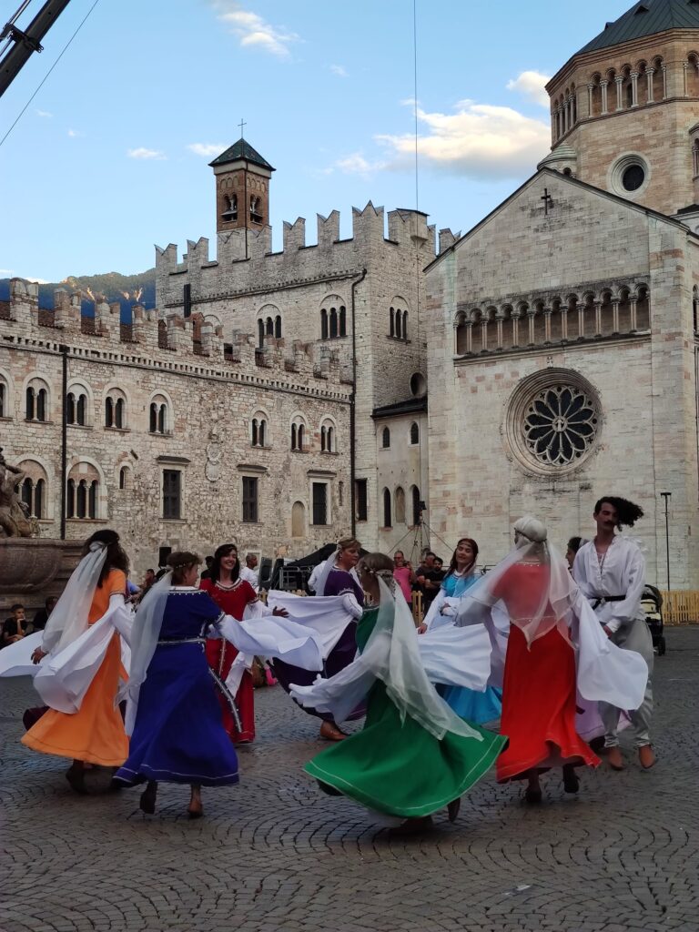 Il gruppo Danticadanza volteggia avvolto in abiti colorati in Piazza Duomo a Trento